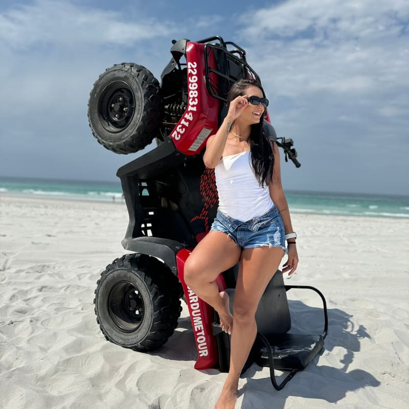 Quadriciclo Cardumetour empinado na Praia Grande com o mar turquesa ao fundo