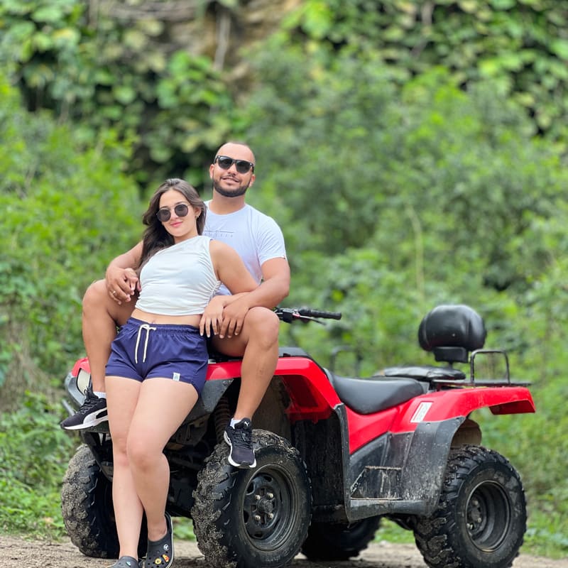 Casal no quadriciclo durante parada na Pedreira, cercados de vegetação