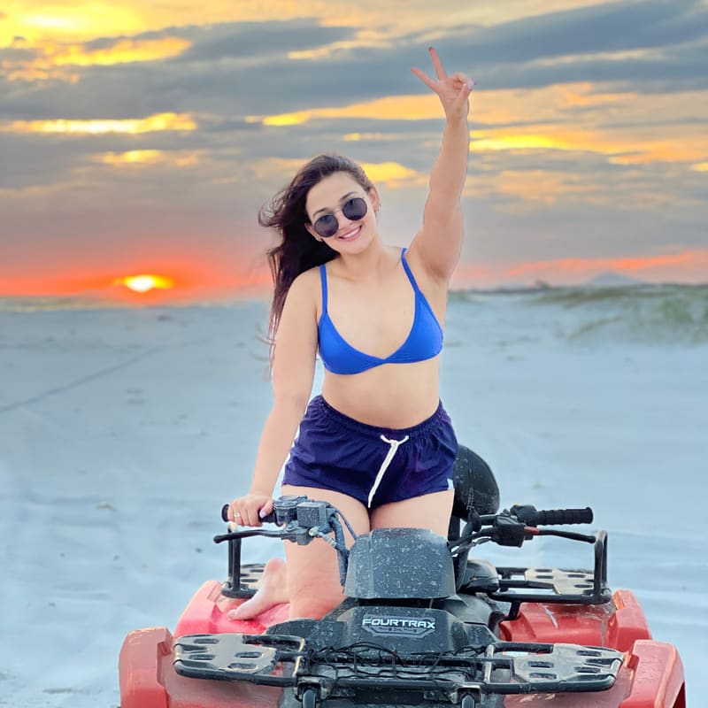 Cliente pilotando o quadriciclo na Praia Grande ao pôr do sol