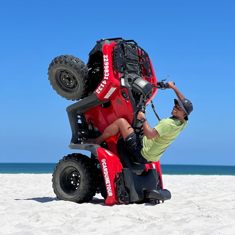 Guia da Cardumetour empinando o quadriciclo para a foto de grau na praia
