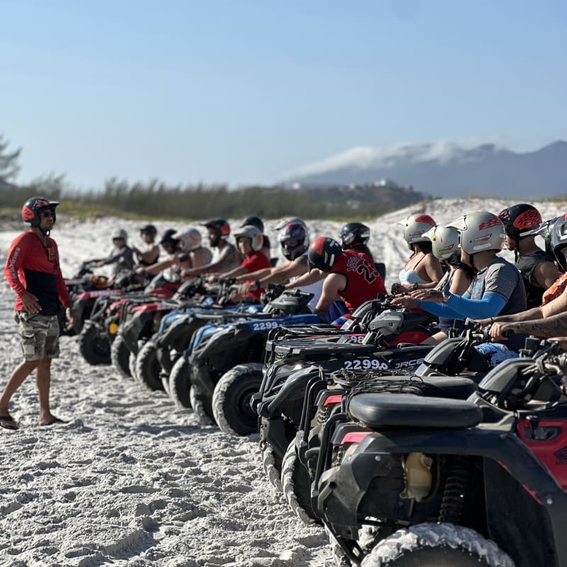 Grupo de clientes com a fila de quadriciclos na praia, com o guia da Cardumetour