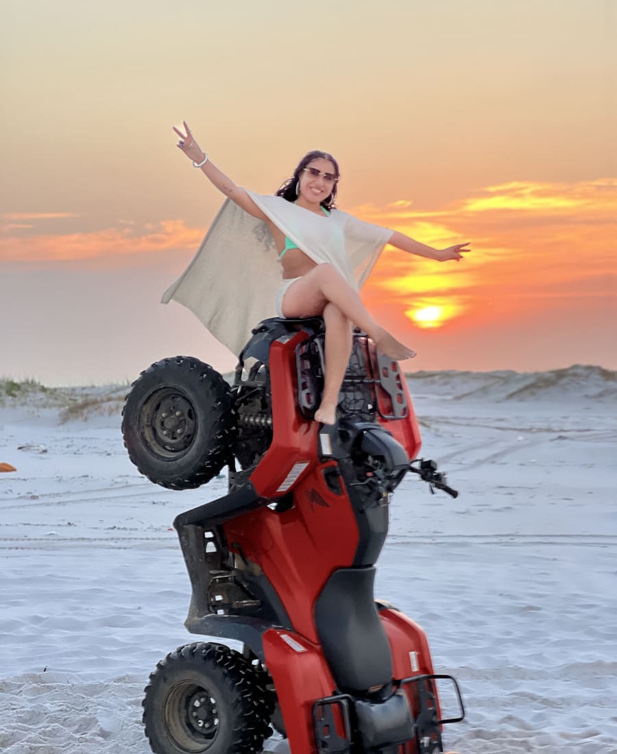 Cliente no quadriciclo empinado da Cardumetour ao pôr do sol na Praia Grande