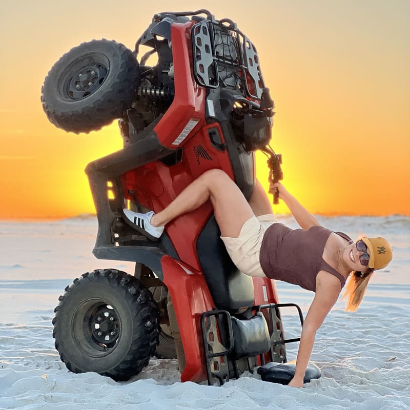 Cliente posando no quadriciclo empinado ao pôr do sol na Praia Grande
